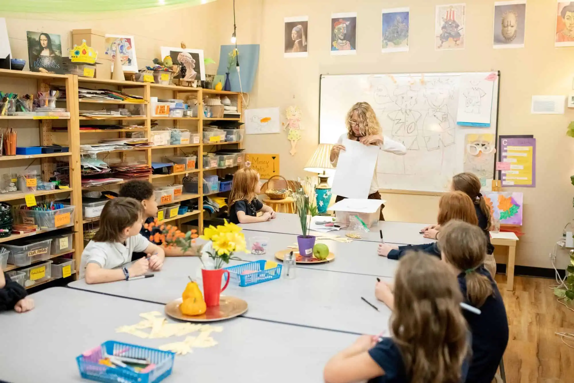 Art teacher holding up an example for Montessori Elementary students