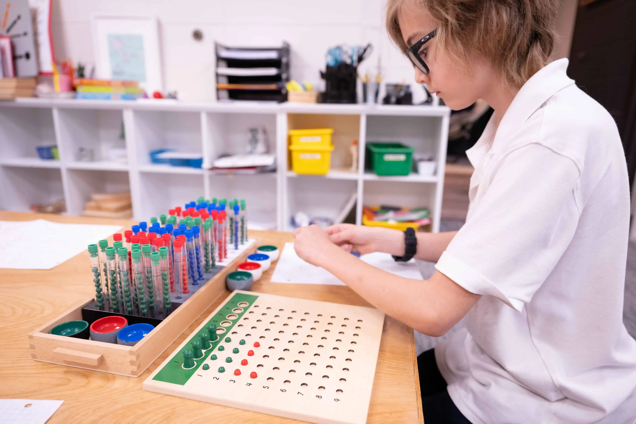 Elementary student learning division with Montessori test tubes
