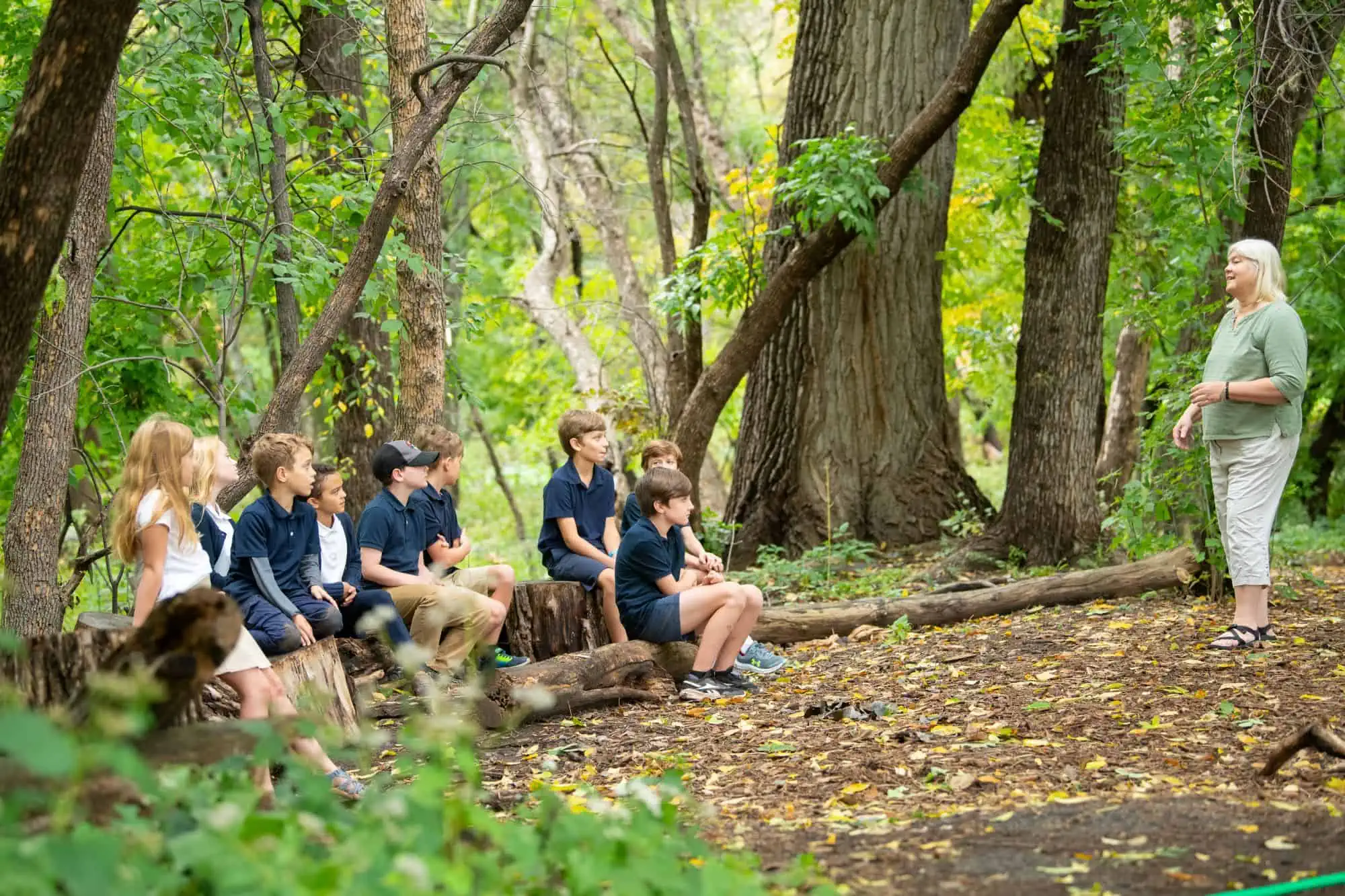 Class of elementary students in the woods for a Montessori science lesson