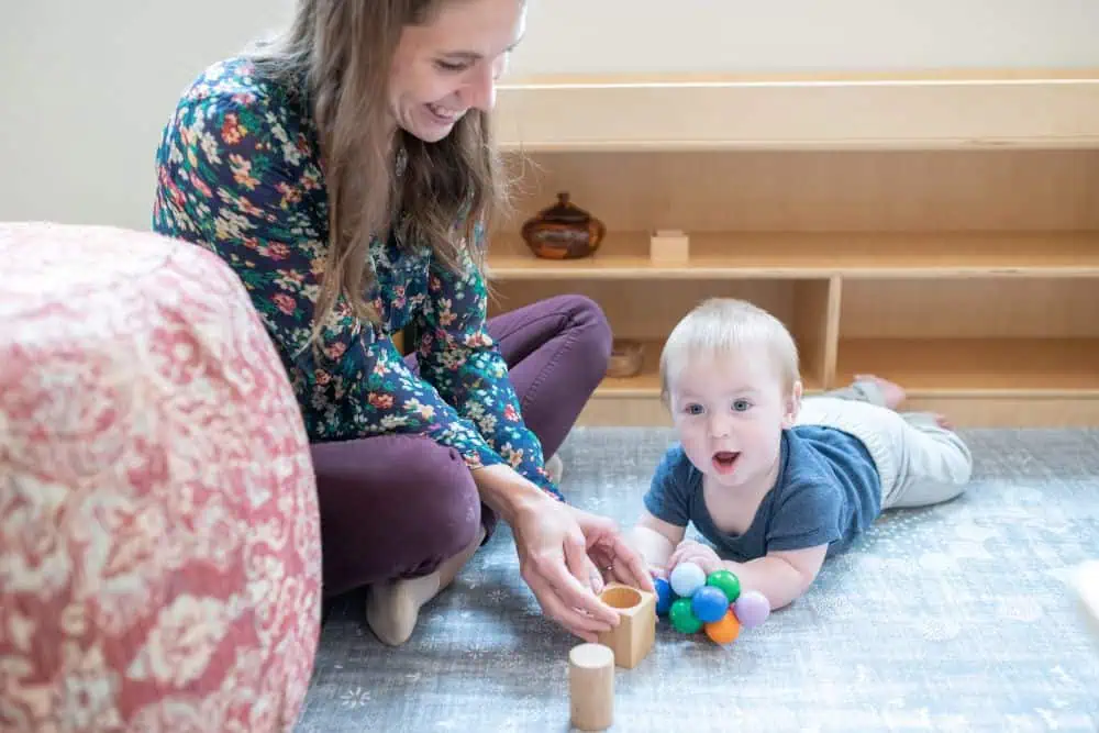 Baby laying on floor playing with sensorial toys in a Christian Montessori daycare