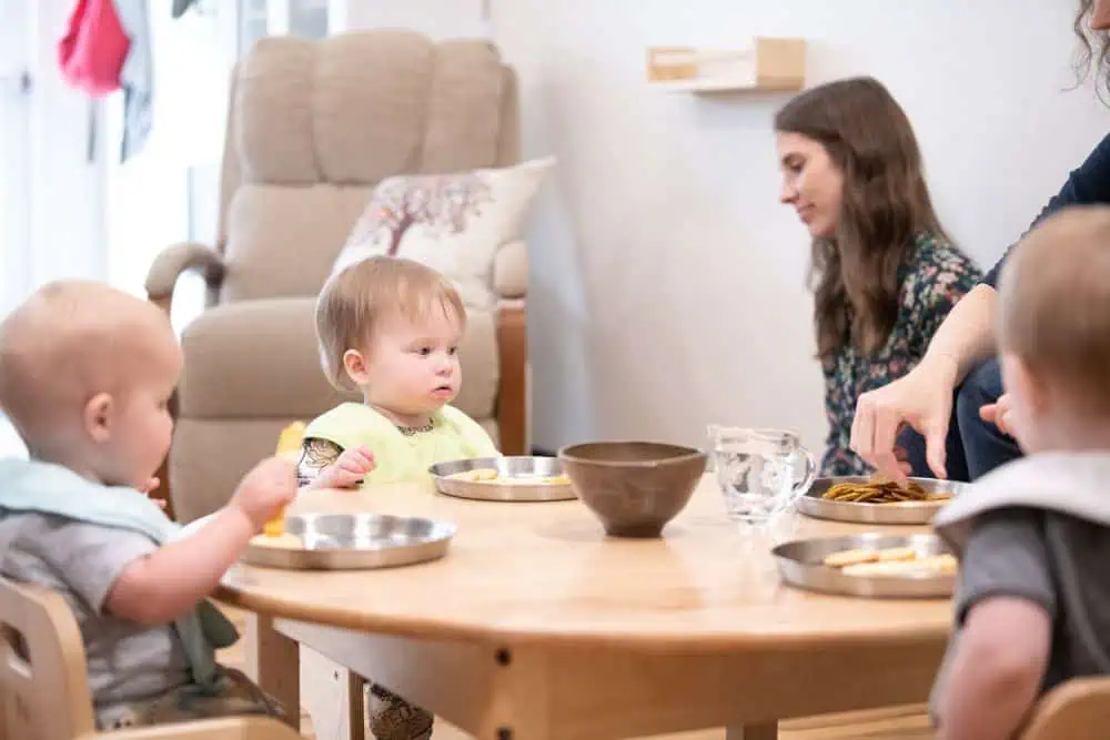 Infants eating at a child-sized table in a Montessori classroom