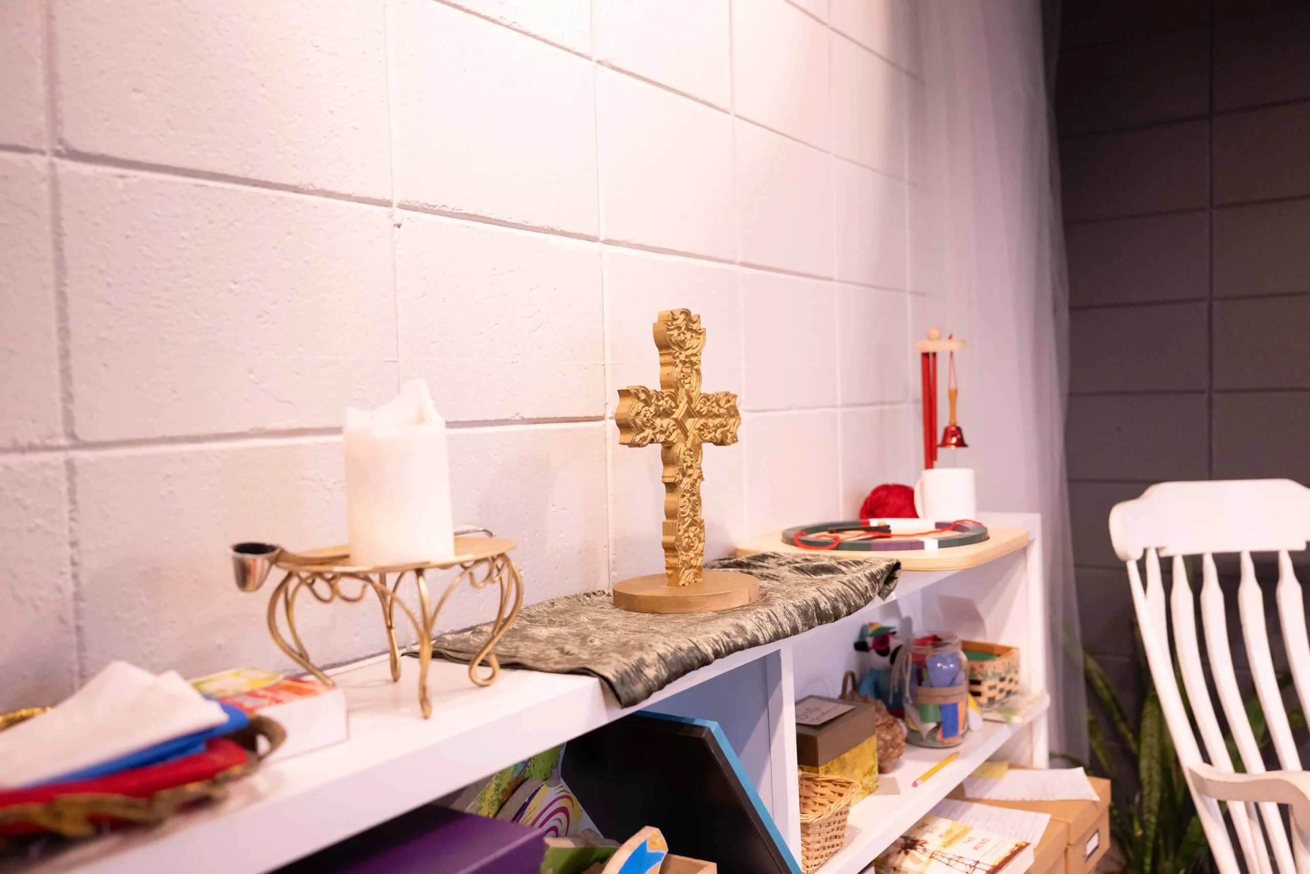 Cross and Candle sitting on the shelf in an Elementary classroom atrium