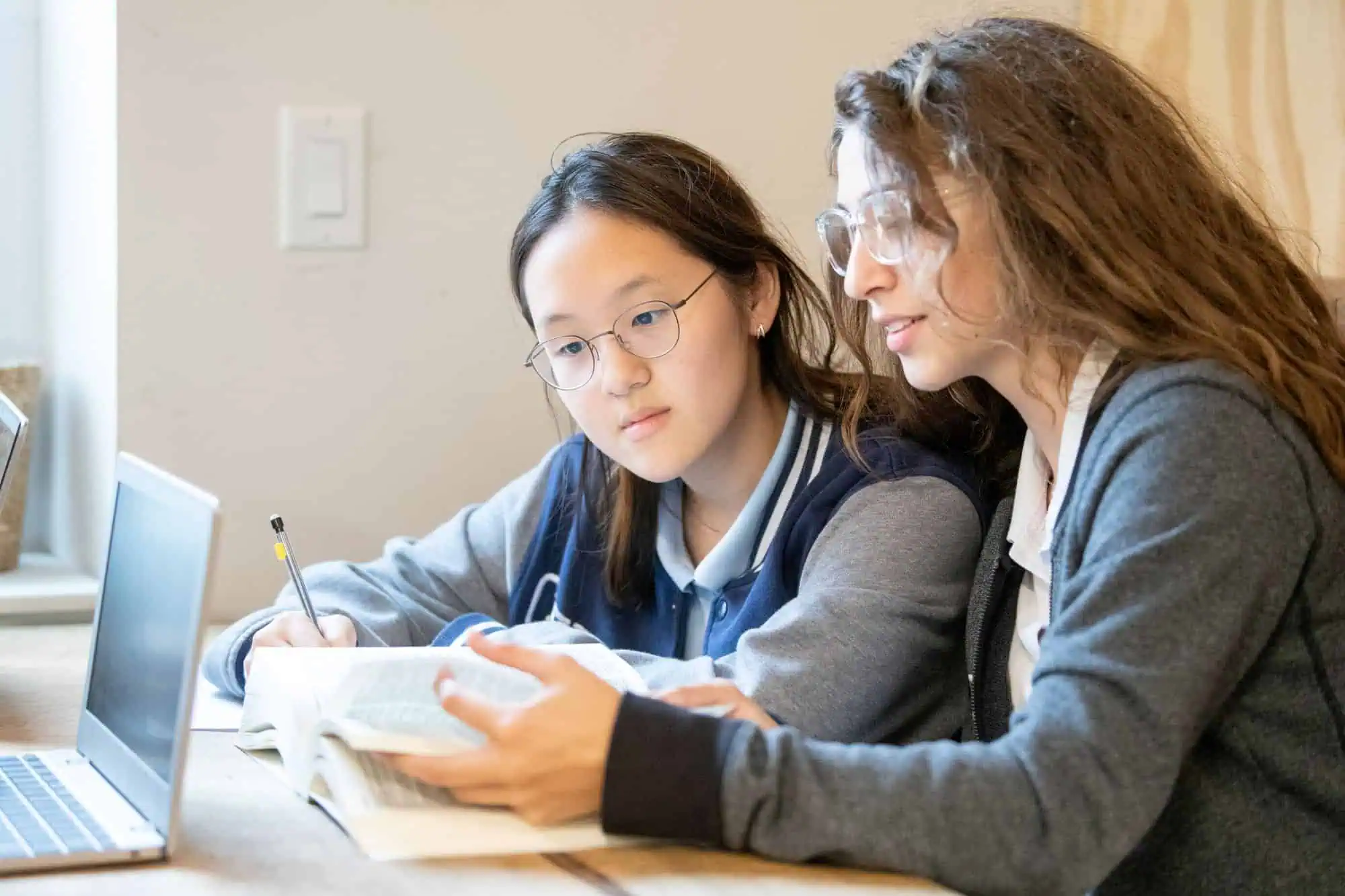 Two High School students reading a book